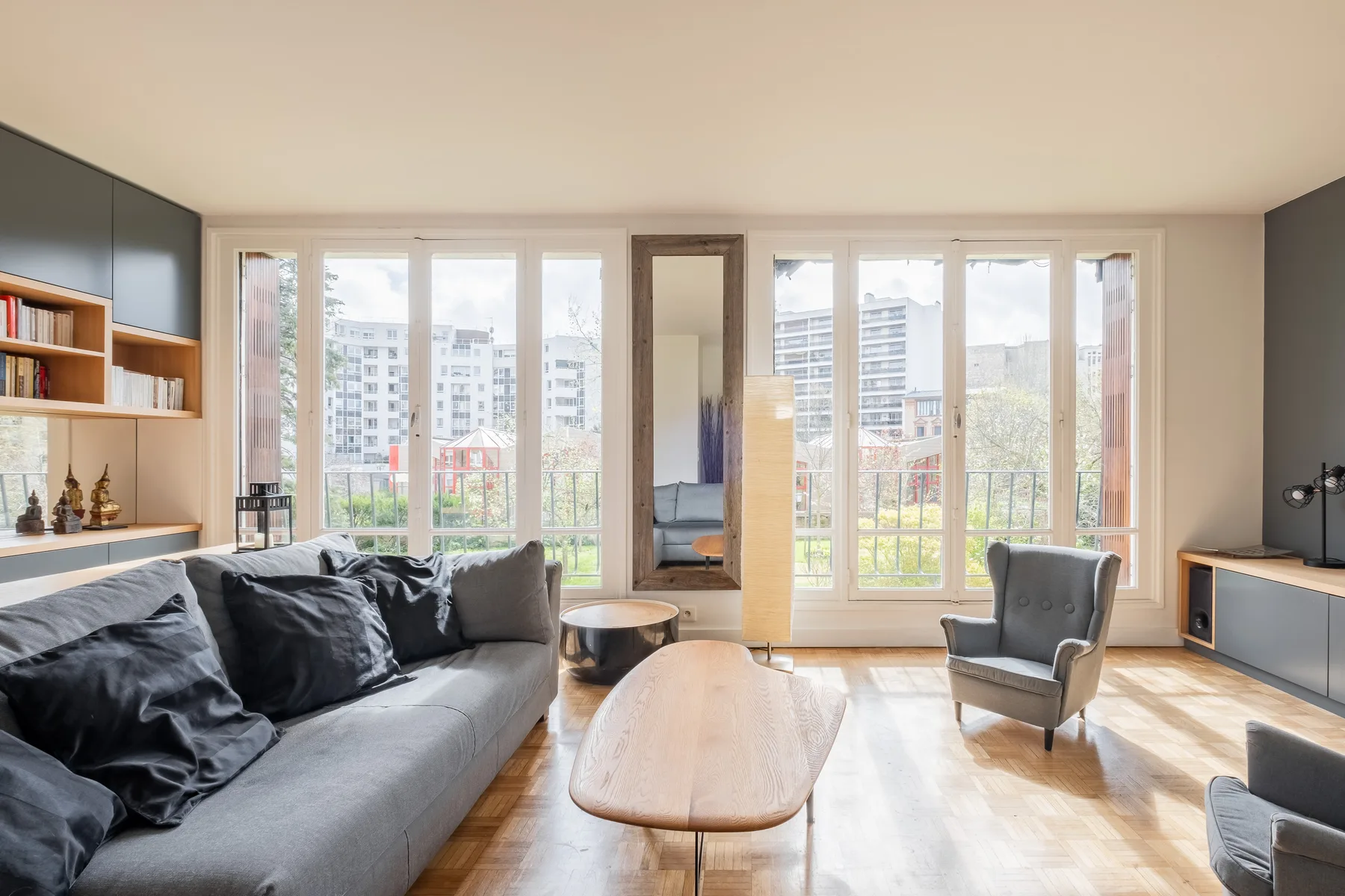 Una sala luminosa con sofá, mesa de centro y ventanas altas.