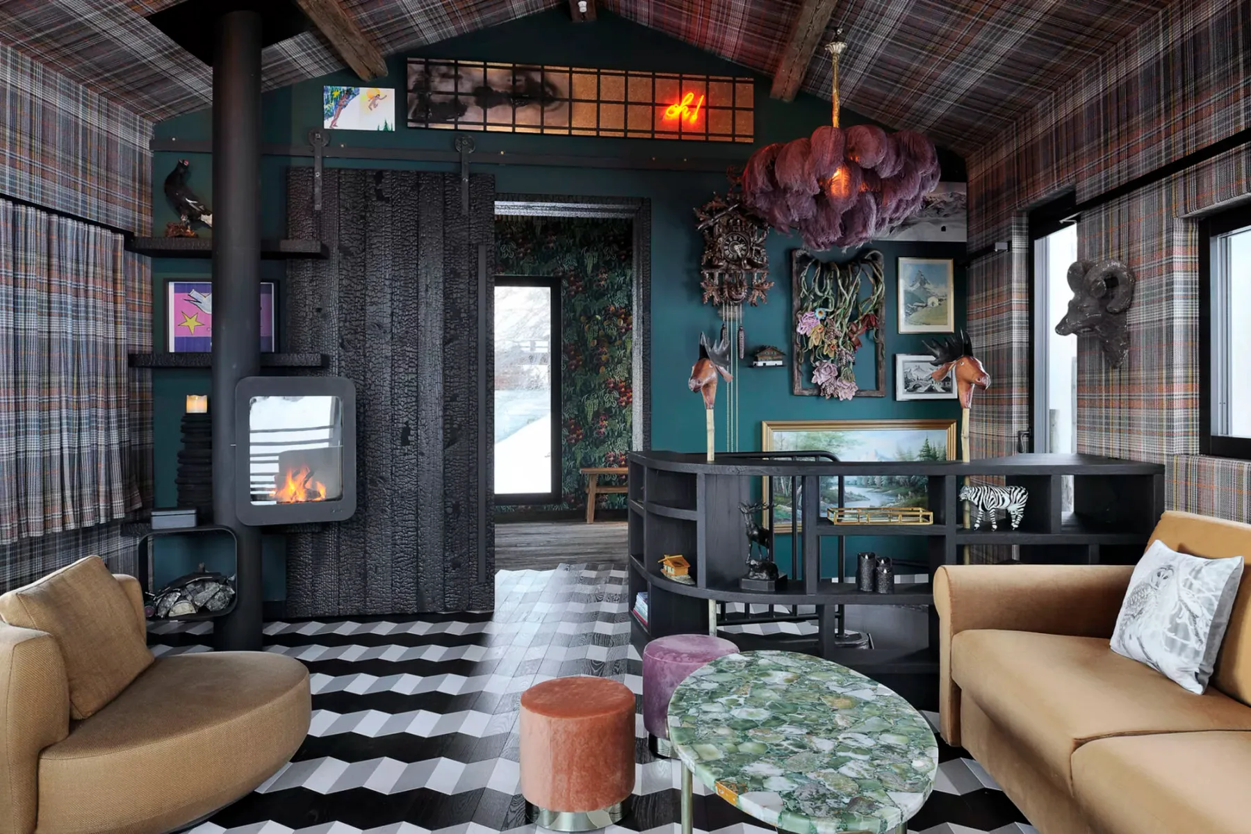 A colorful living room with patterned walls, a central display shelf, and seating.