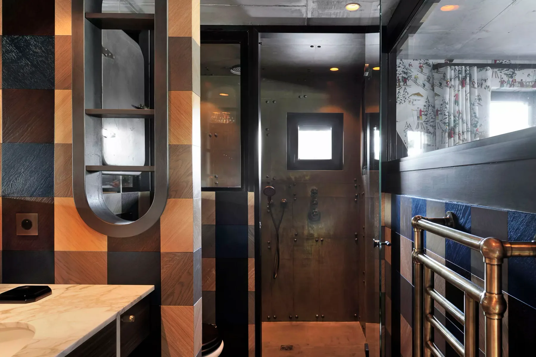 A tiled bathroom with a shower area and a wooden vanity counter.