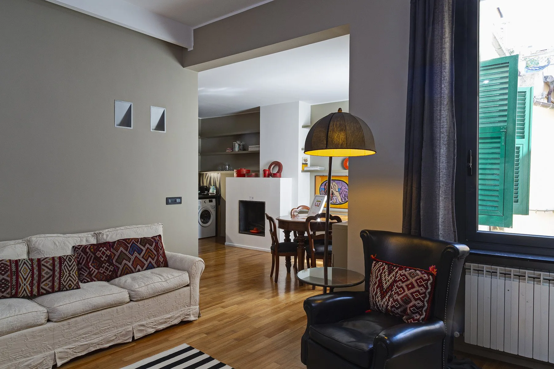 Una sala de estar y comedor con asientos, una mesa y una lámpara colgante grande.