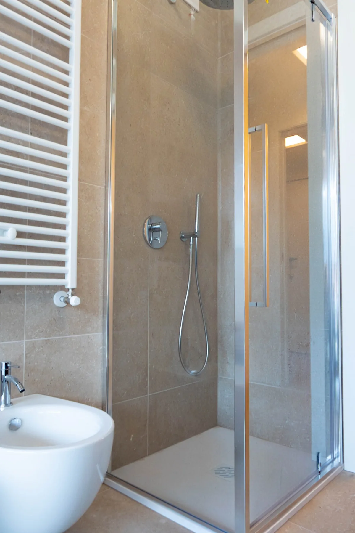 A bathroom with a glass shower and a sink.