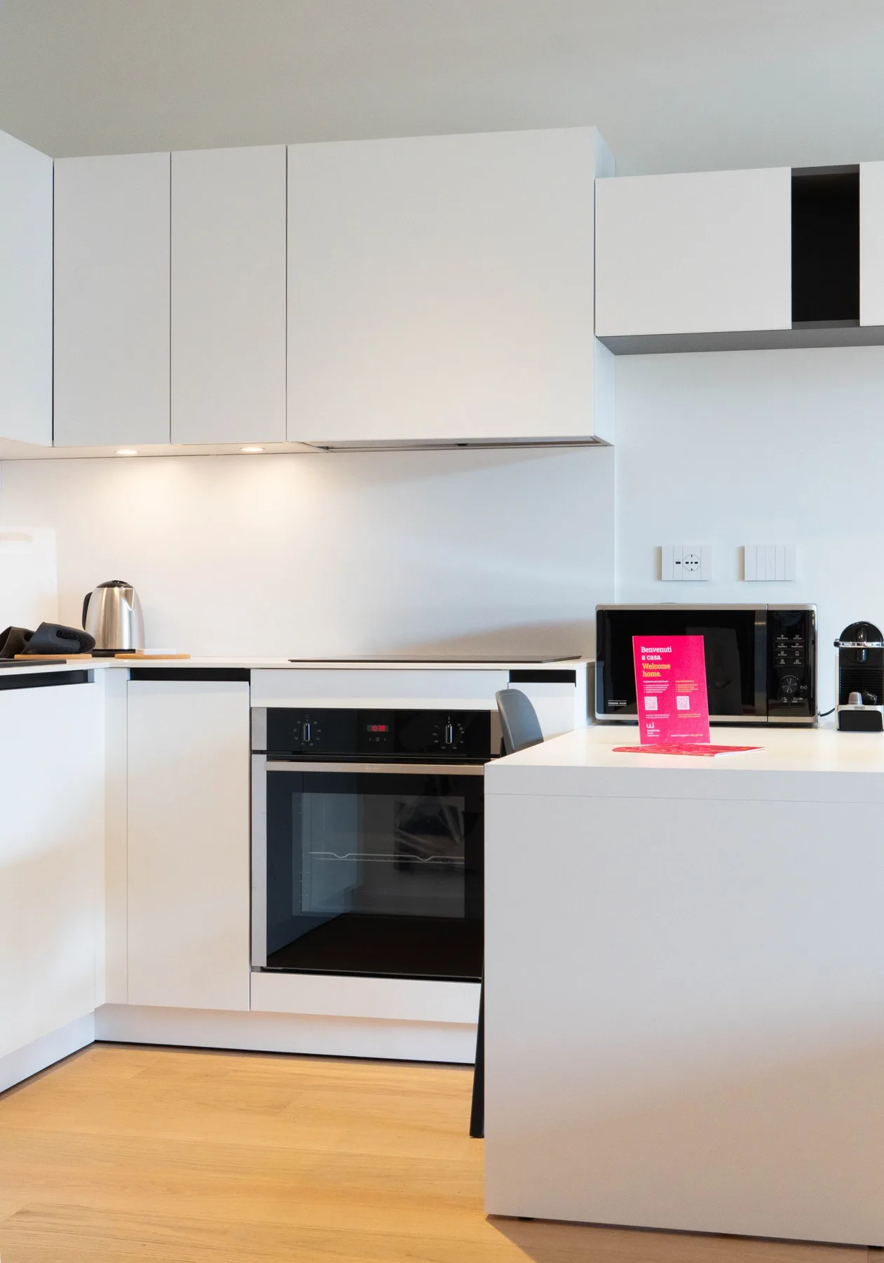 A modern kitchen with white cabinets, an oven, and a countertop.