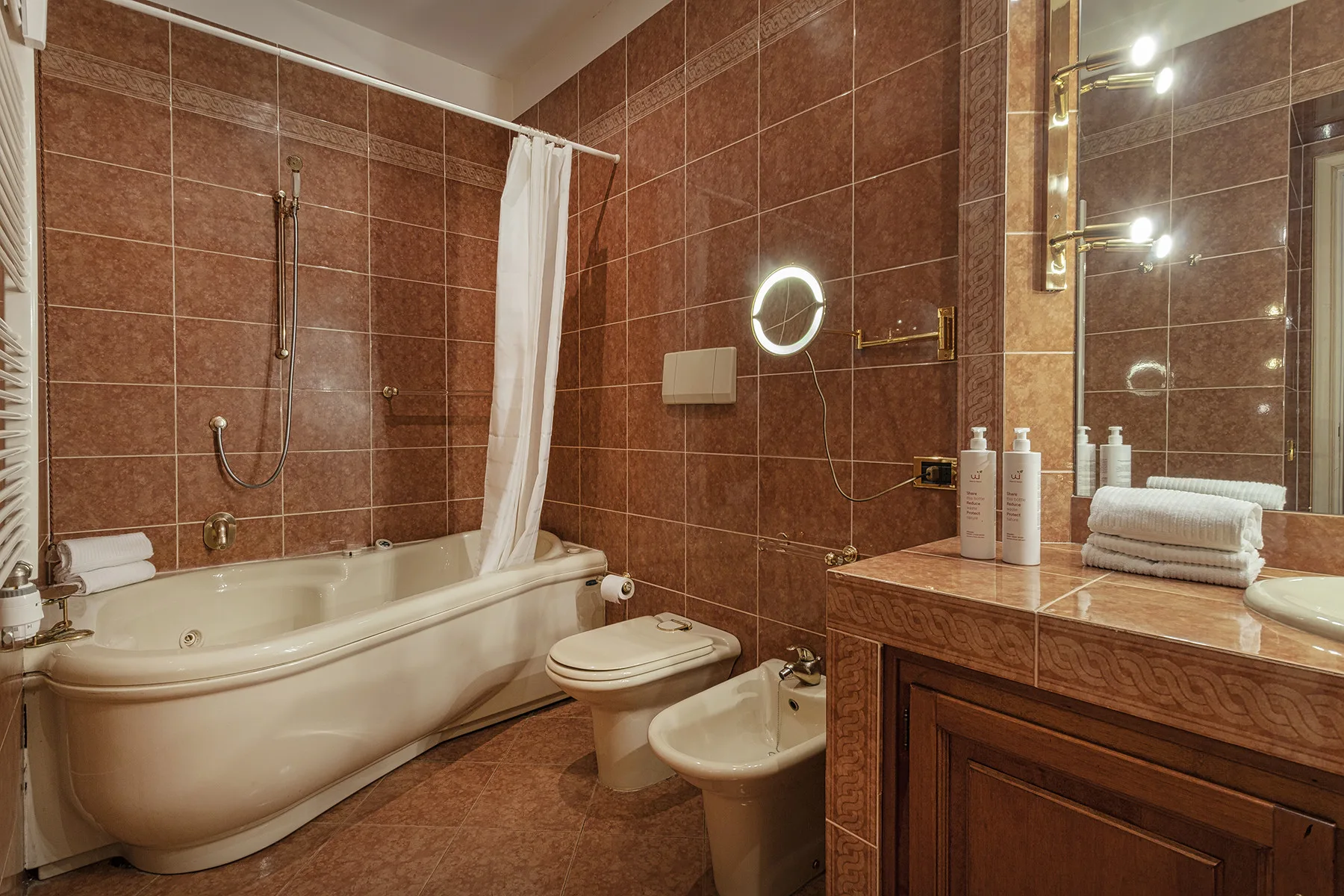Un baño con azulejos, bañera, inodoro, bidé y tocador.
