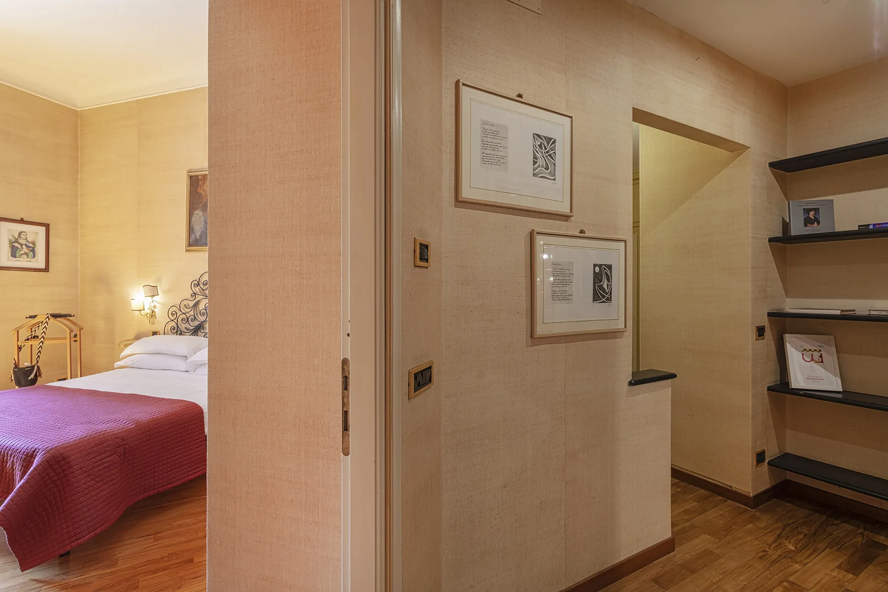 Un dormitorio con una cama y cuadros en las paredes.