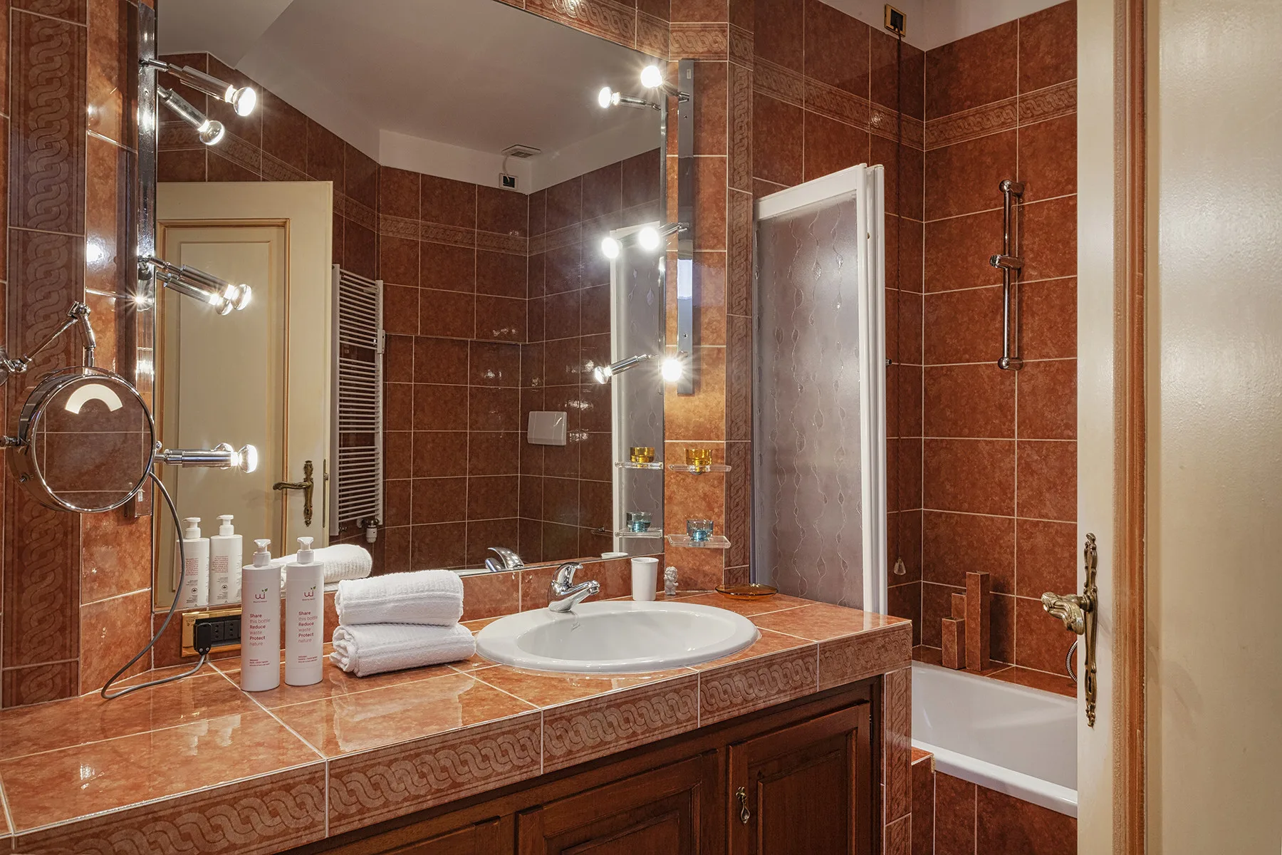 Un baño con azulejos, lavabo con mueble y bañera.