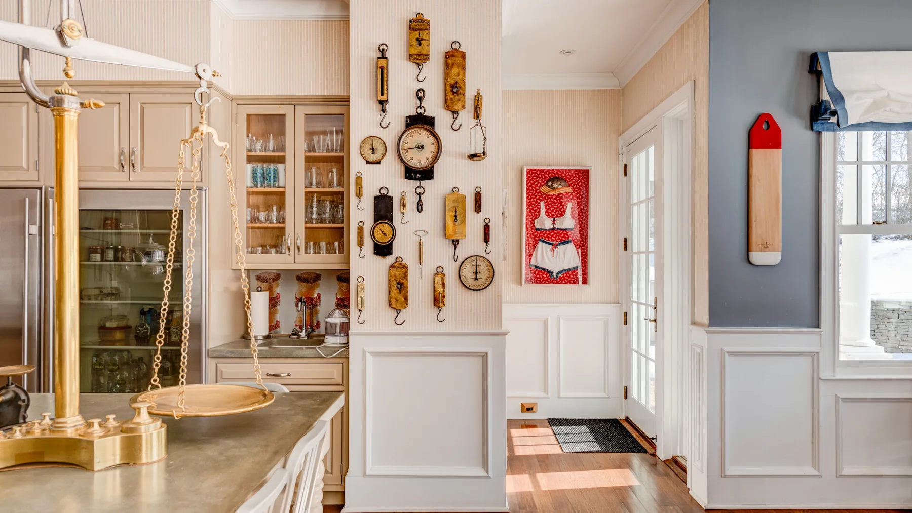Una cocina con una balanza colgante de latón y relojes decorativos en la pared.
