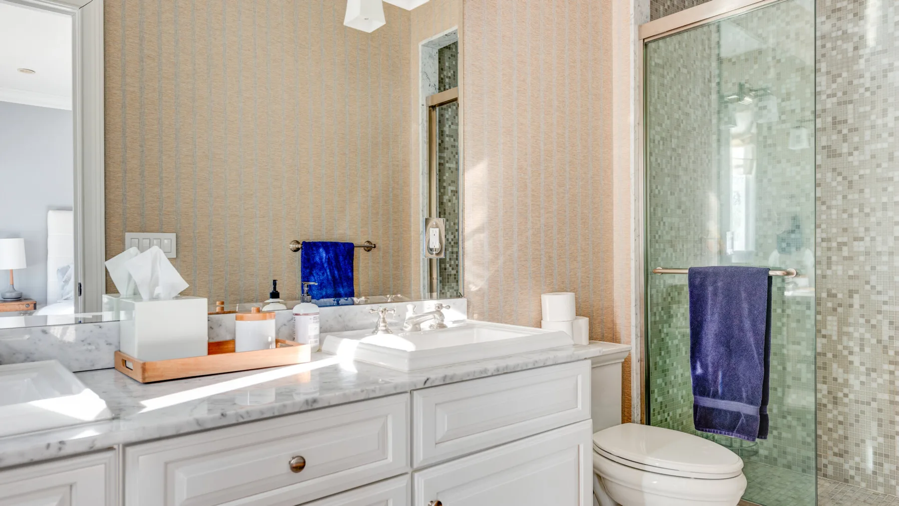 Un lavabo de baño está junto a una ducha de vidrio y un inodoro.
