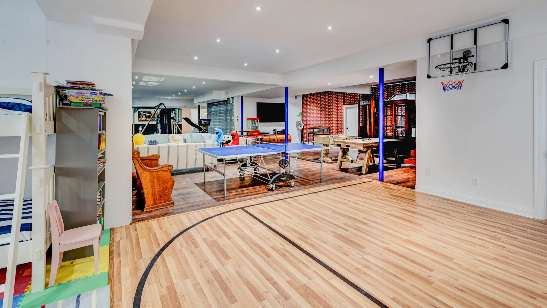 Una amplia sala de recreación interior cuenta con una canasta de baloncesto y una mesa de ping-pong.