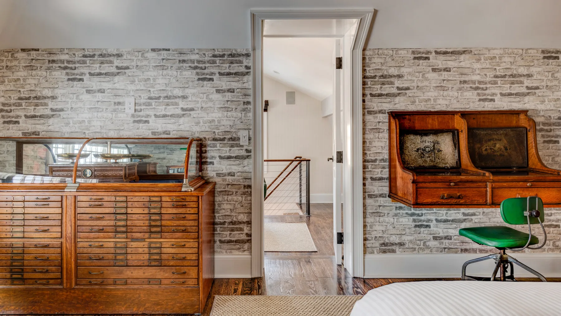 Una habitación con muebles de madera, paredes de ladrillo y una puerta abierta.