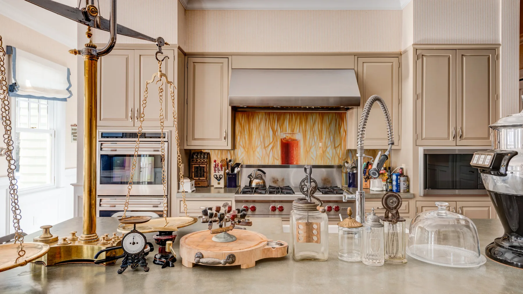 Una cocina luminosa con una gran isla y utensilios de cocina sobre la encimera.