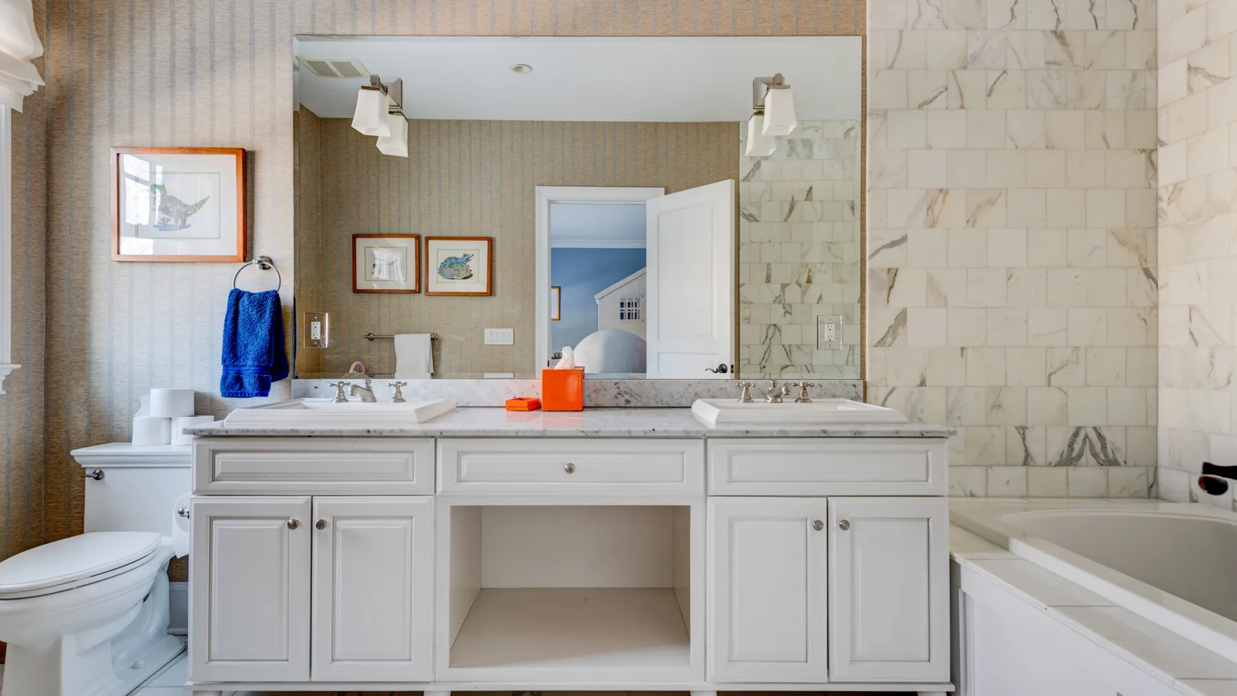 Un lavabo de baño con un espejo grande y una bañera.