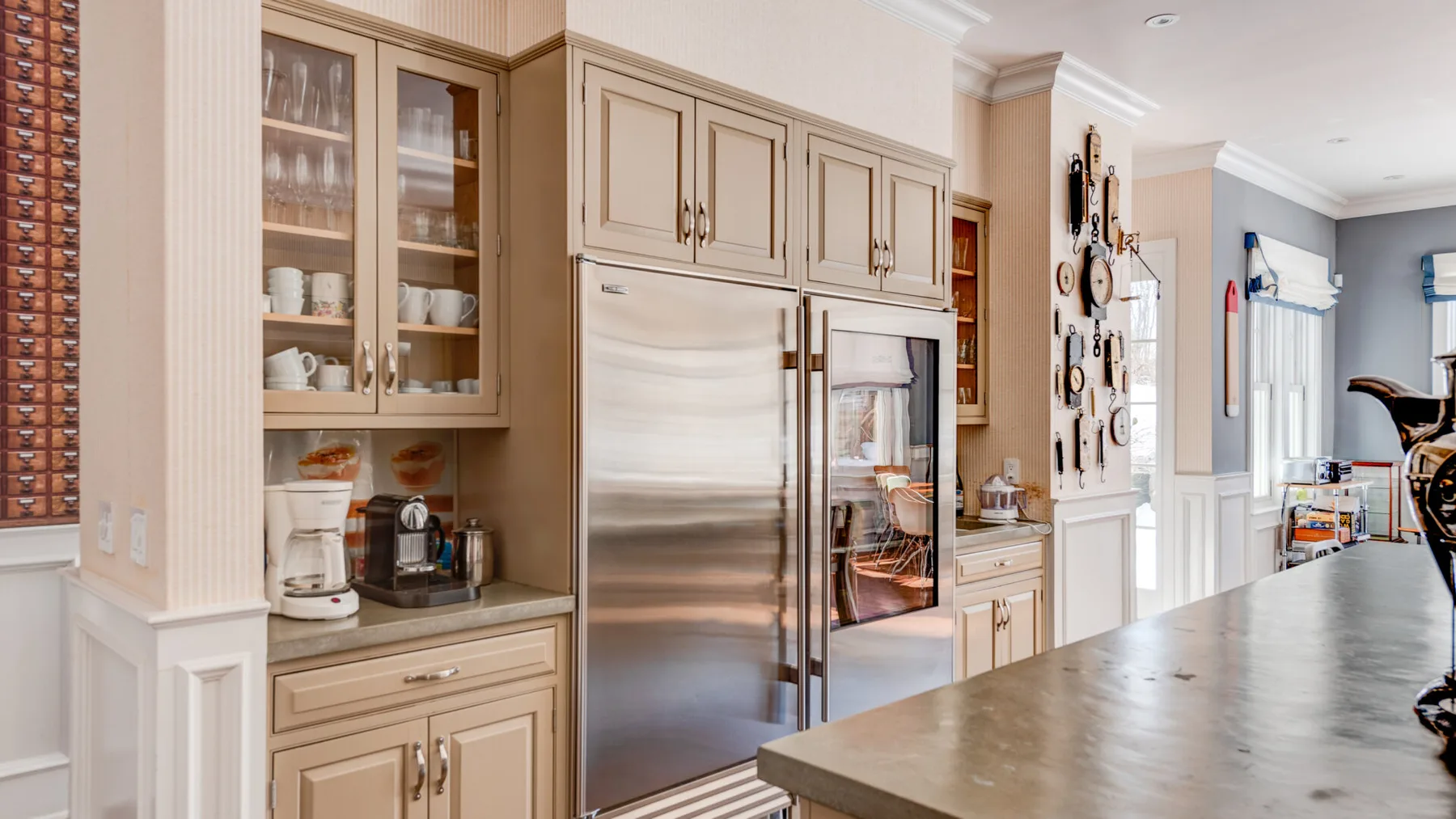 Una cocina luminosa con un refrigerador de acero inoxidable y una amplia encimera de isla.