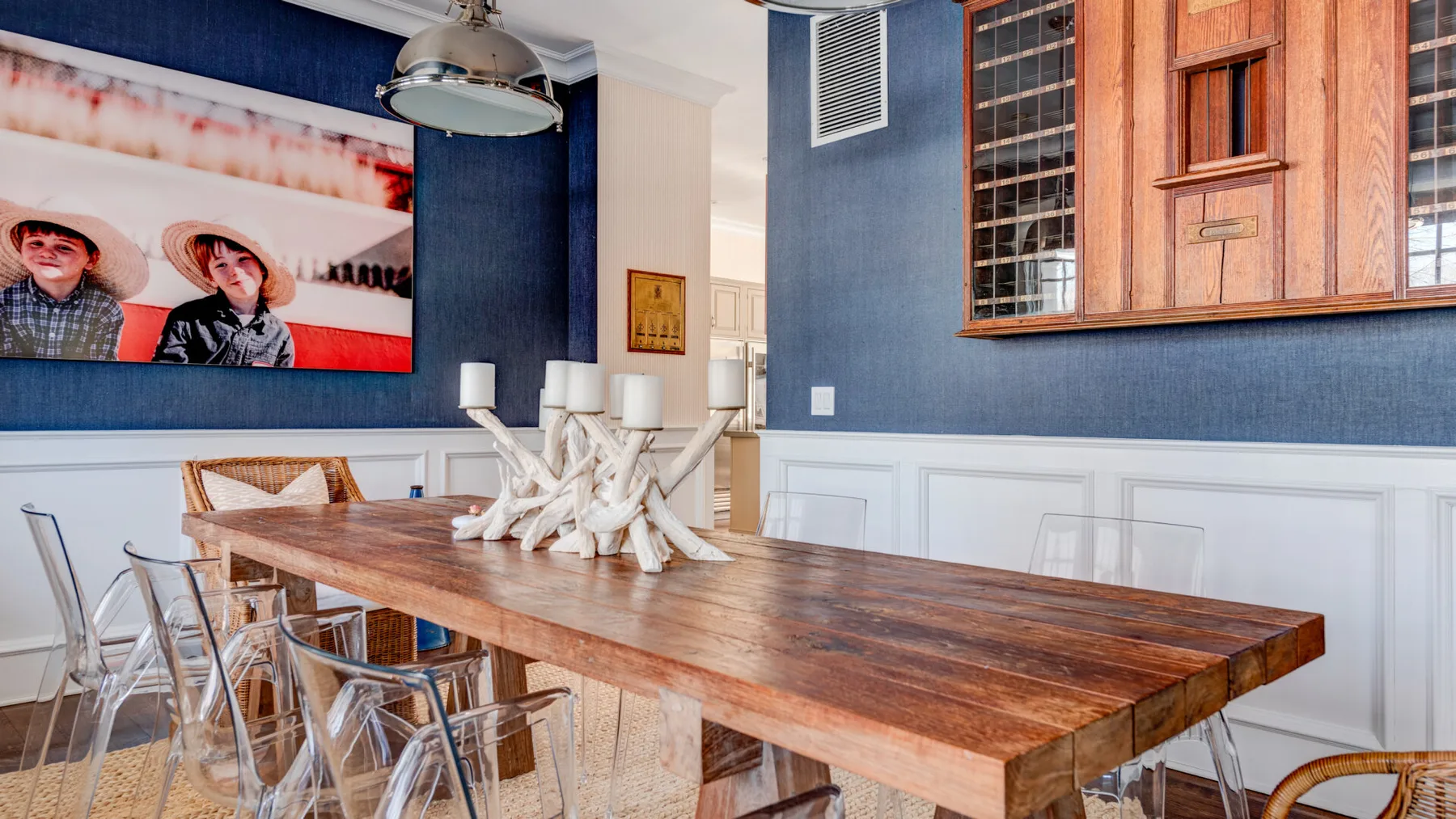 Un comedor con una mesa larga de madera y un centro de mesa blanco escultórico.
