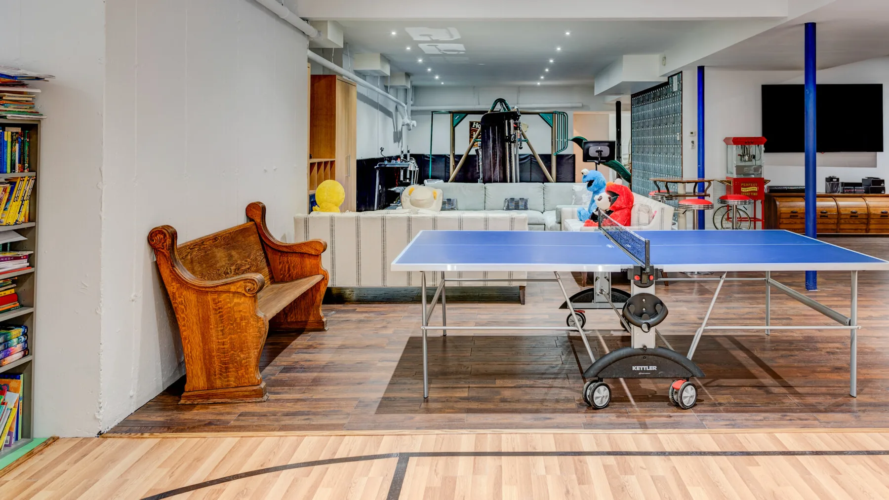 Una sala de recreación interior tiene una mesa de ping-pong y asientos.