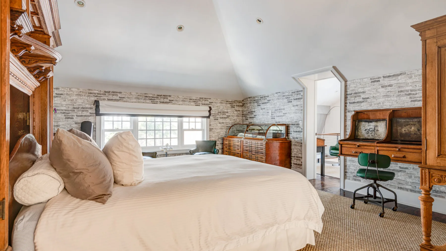 Un dormitorio con una cama grande, una ventana y muebles de madera.