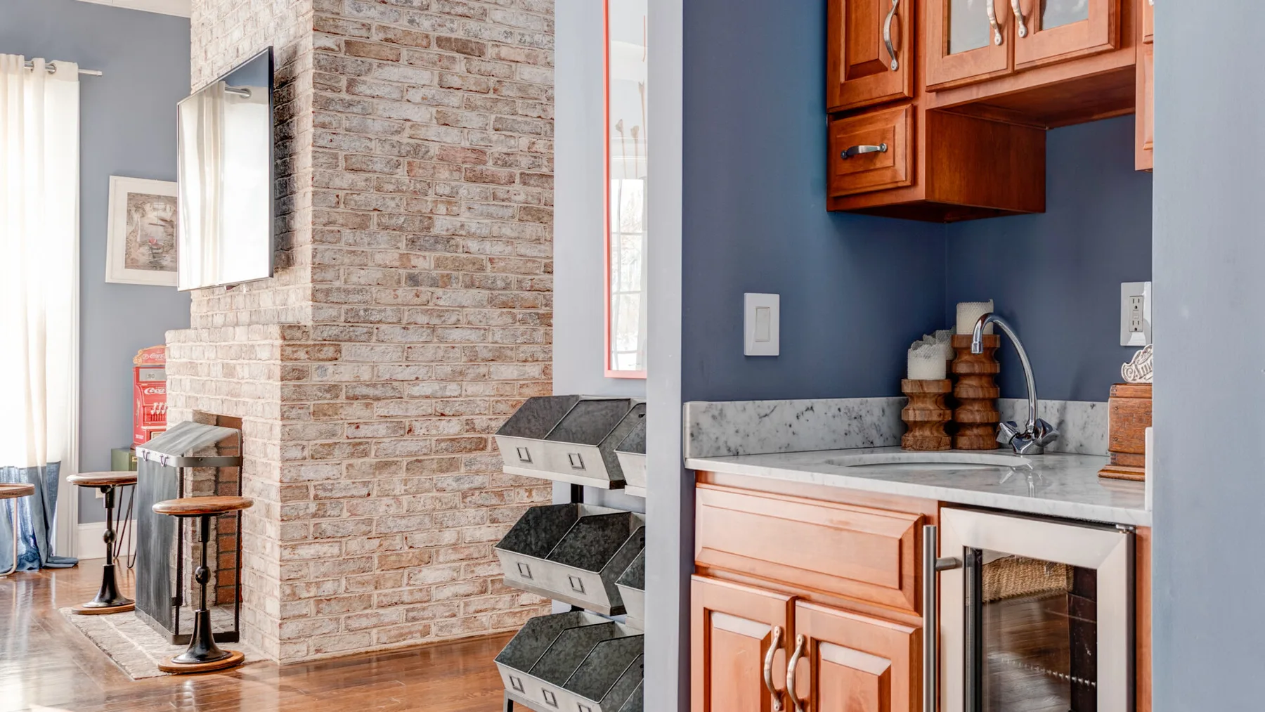 Una cocina con gabinetes de madera, una encimera de piedra y una pared de ladrillo.