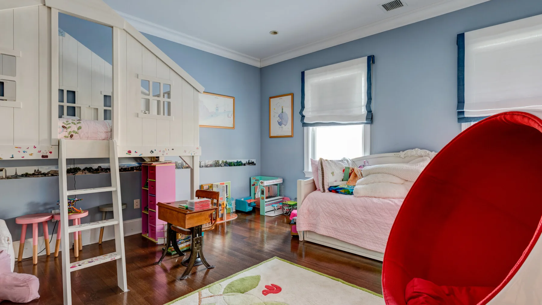 Un dormitorio con una cama, almacenamiento empotrado y una pequeña zona de juegos.