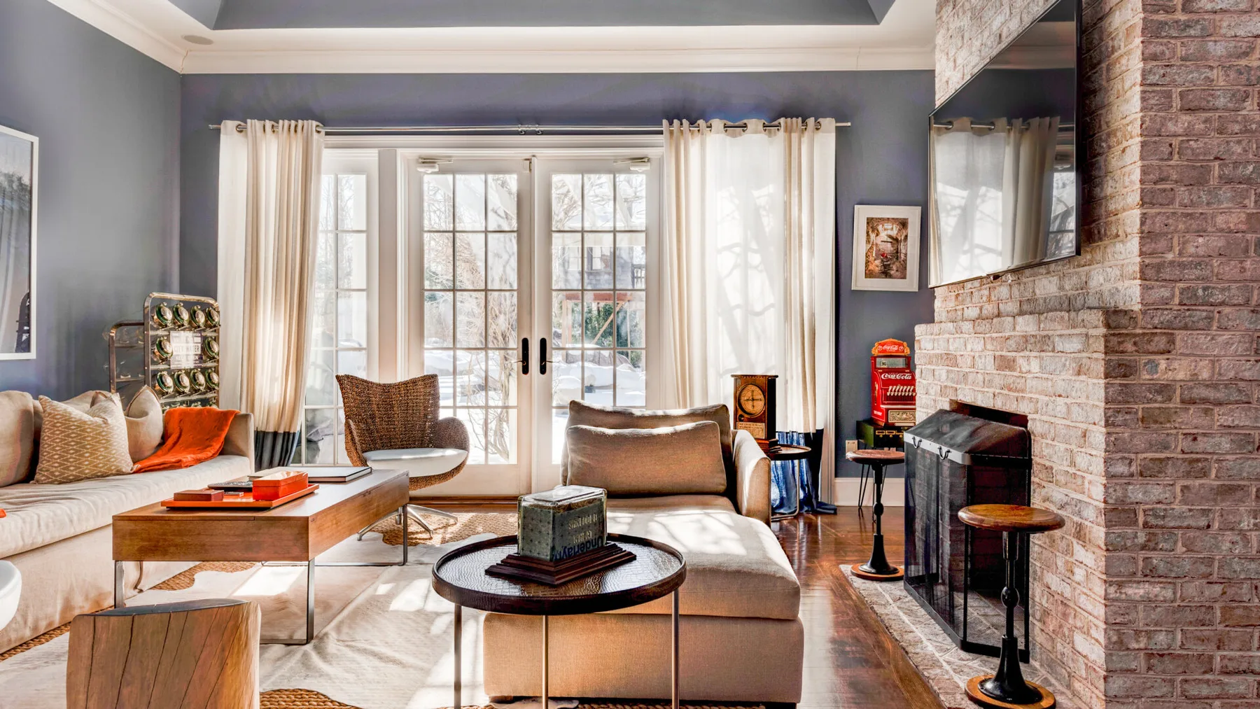 Una sala de estar con asientos, una mesa de centro y ventanas altas con cortinas.