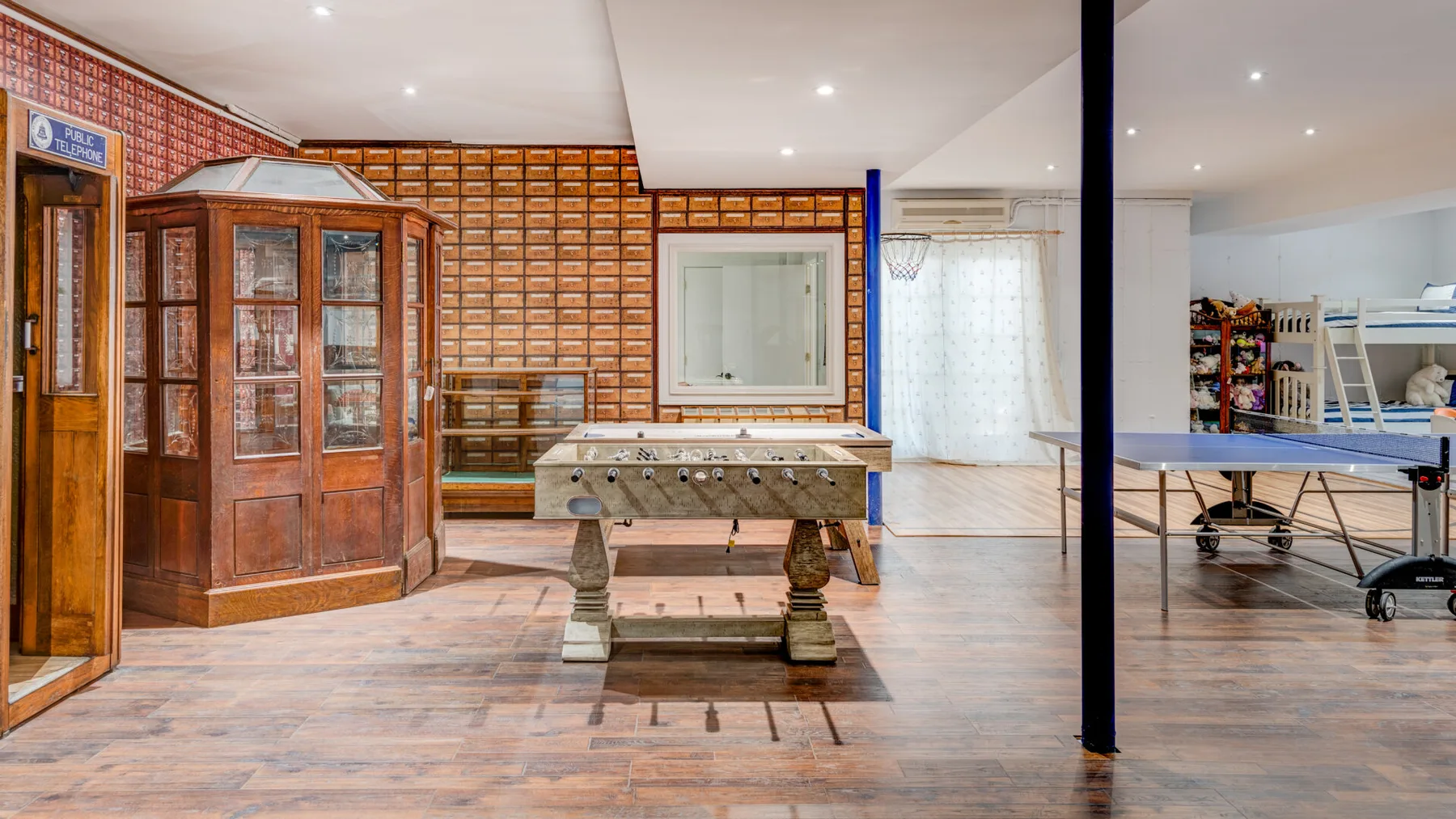 Una sala de recreación con una mesa de futbolín y vitrinas con puertas de vidrio.