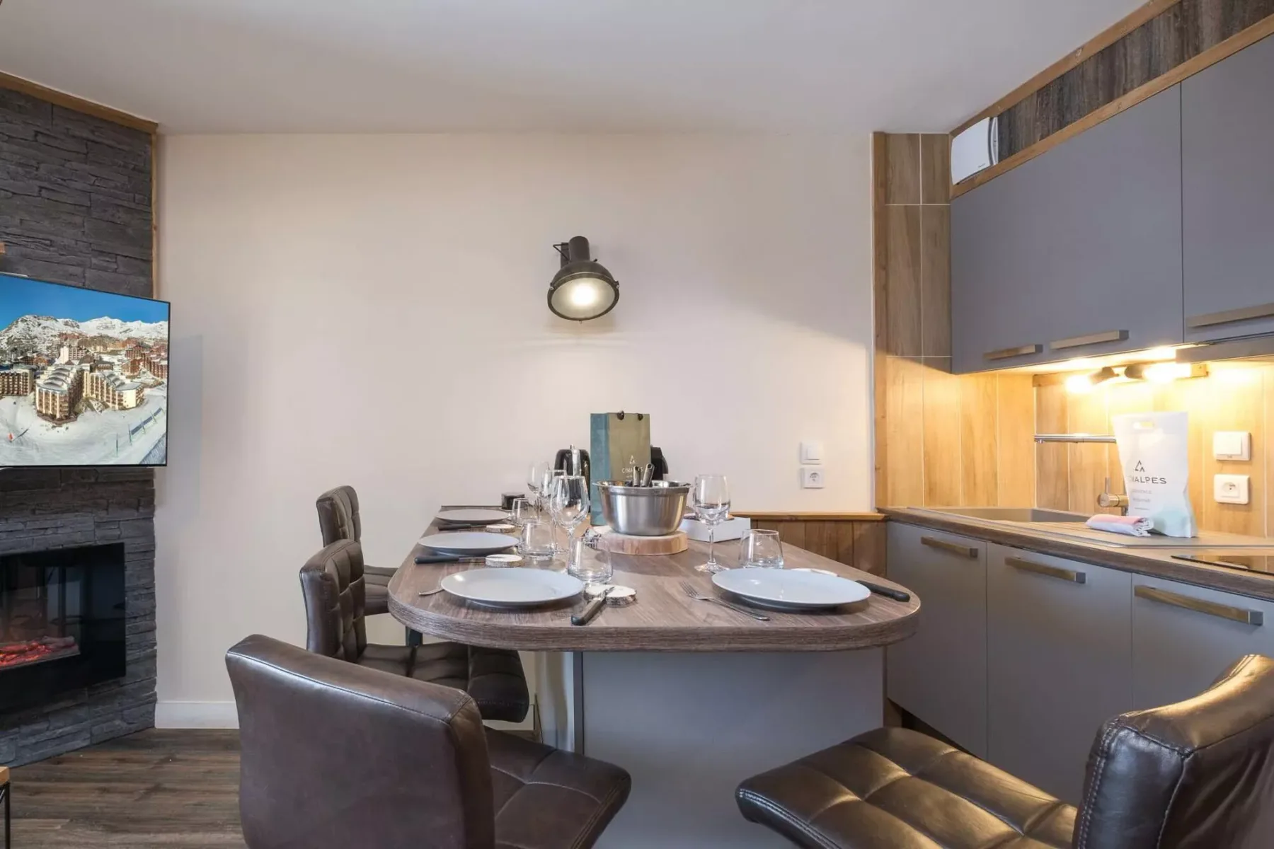 Comedor con una mesa puesta junto a una cocina compacta.
