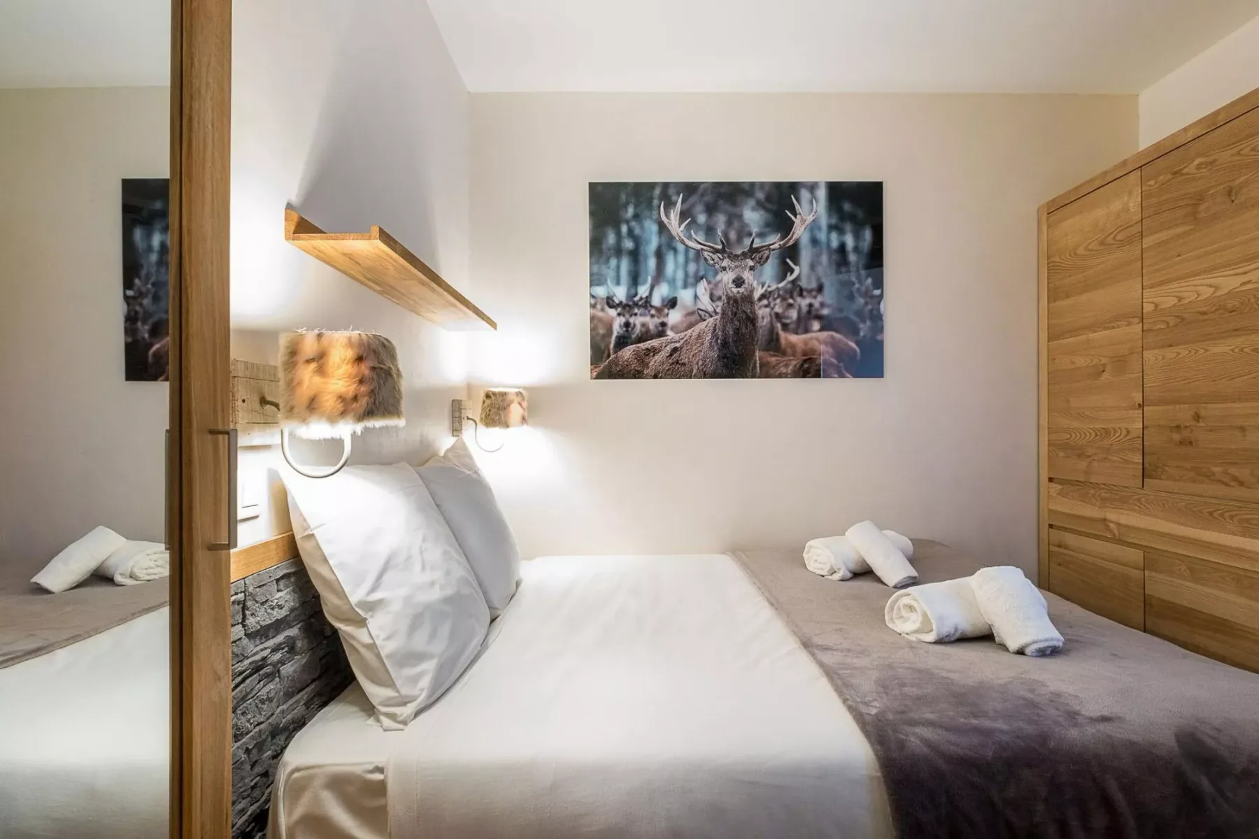Dormitorio con cama, armario de madera y un cuadro de fauna.