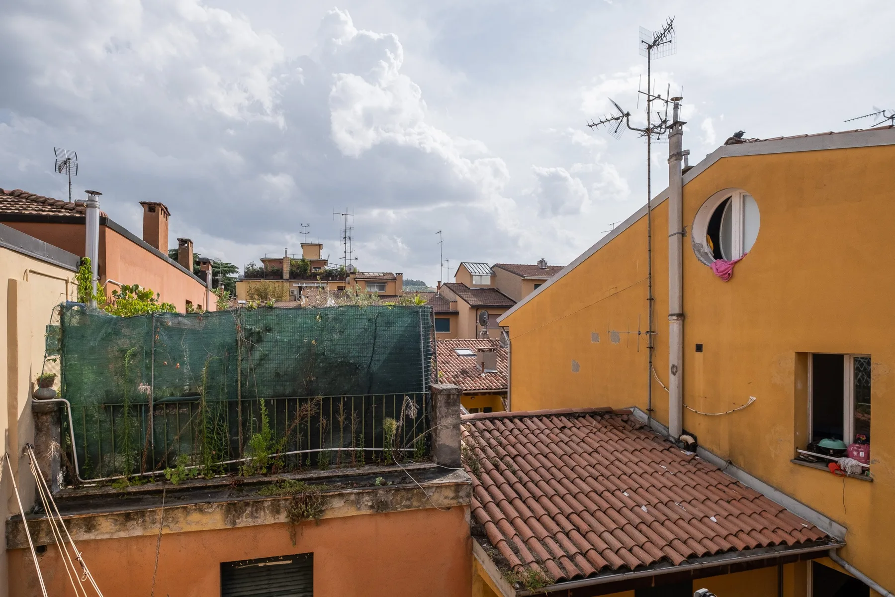 Se ven tejados y edificios vecinos bajo un cielo nublado.