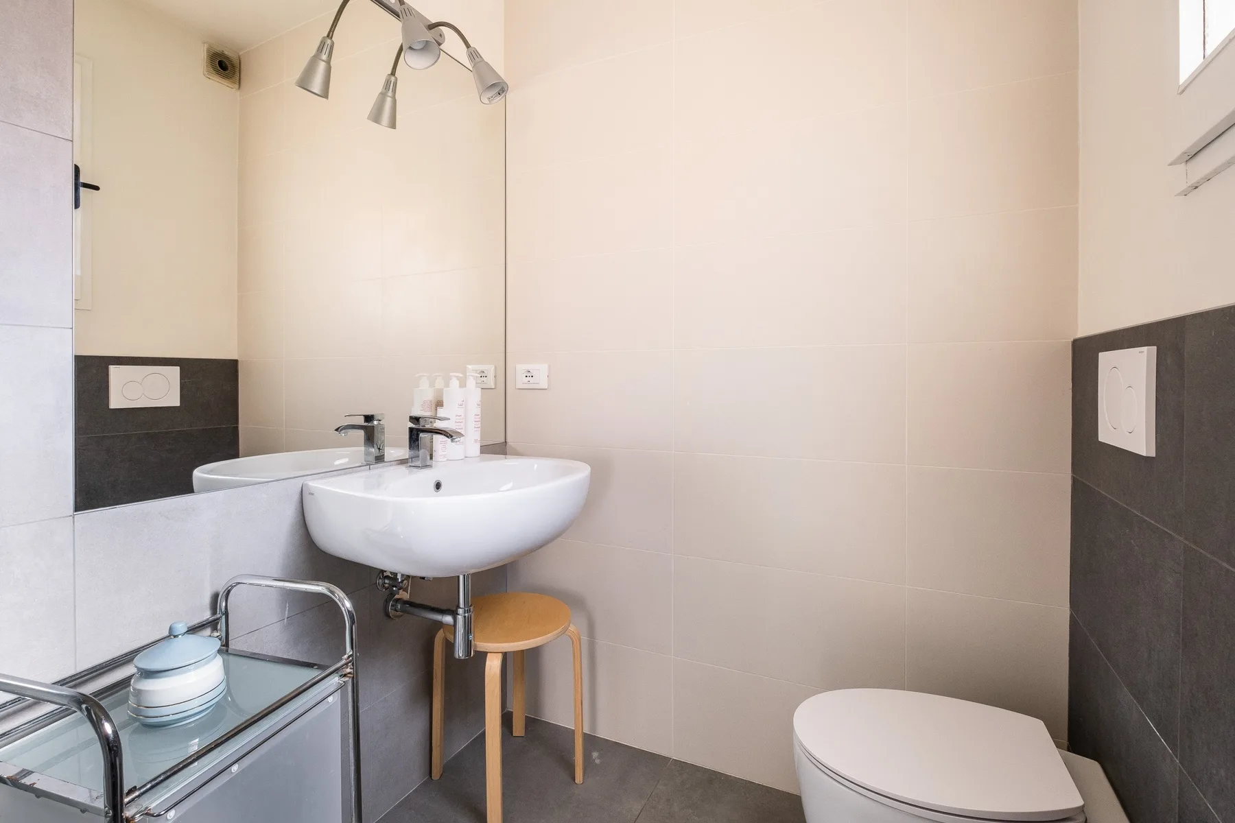 Un baño con lavabo, espejo e inodoro.