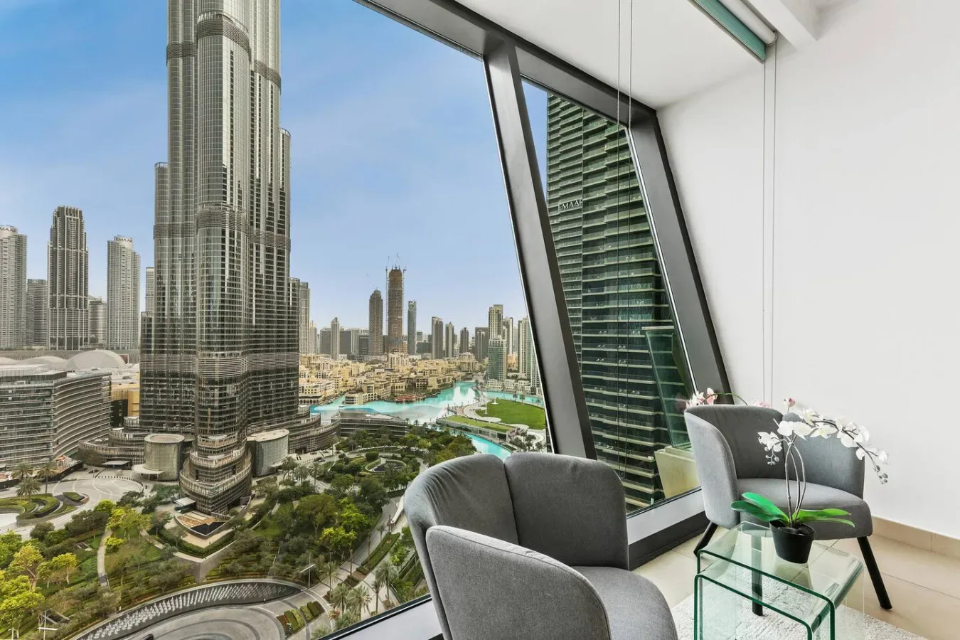 A modern sitting area overlooks a city skyline through large windows.
