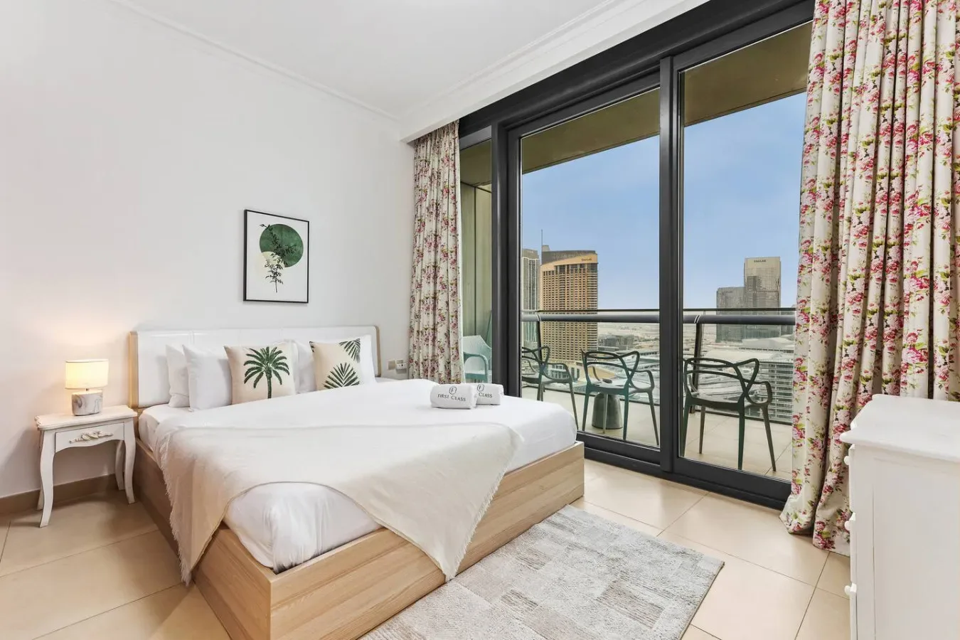 A bedroom with a bed beside glass doors opening onto a balcony.