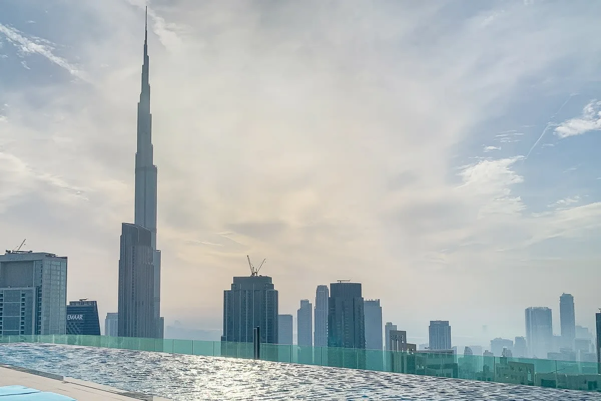 City skyline with a very tall tower rising above surrounding buildings.