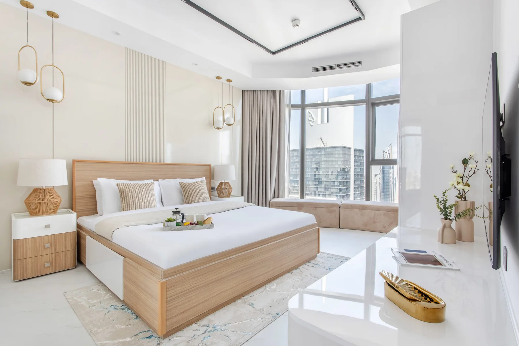 A bright bedroom with a wood-framed bed beside large windows.