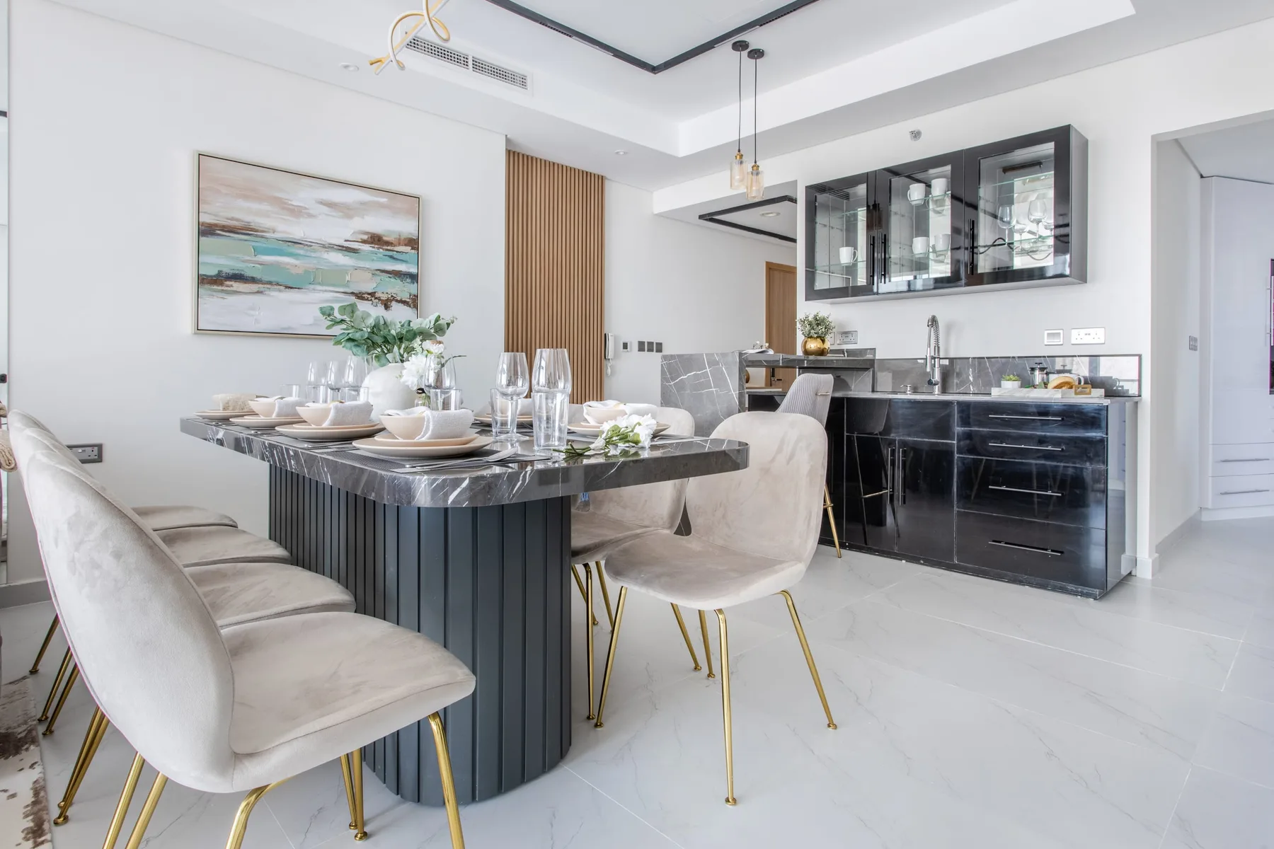 A bright dining area with a set table beside a dark kitchen island.