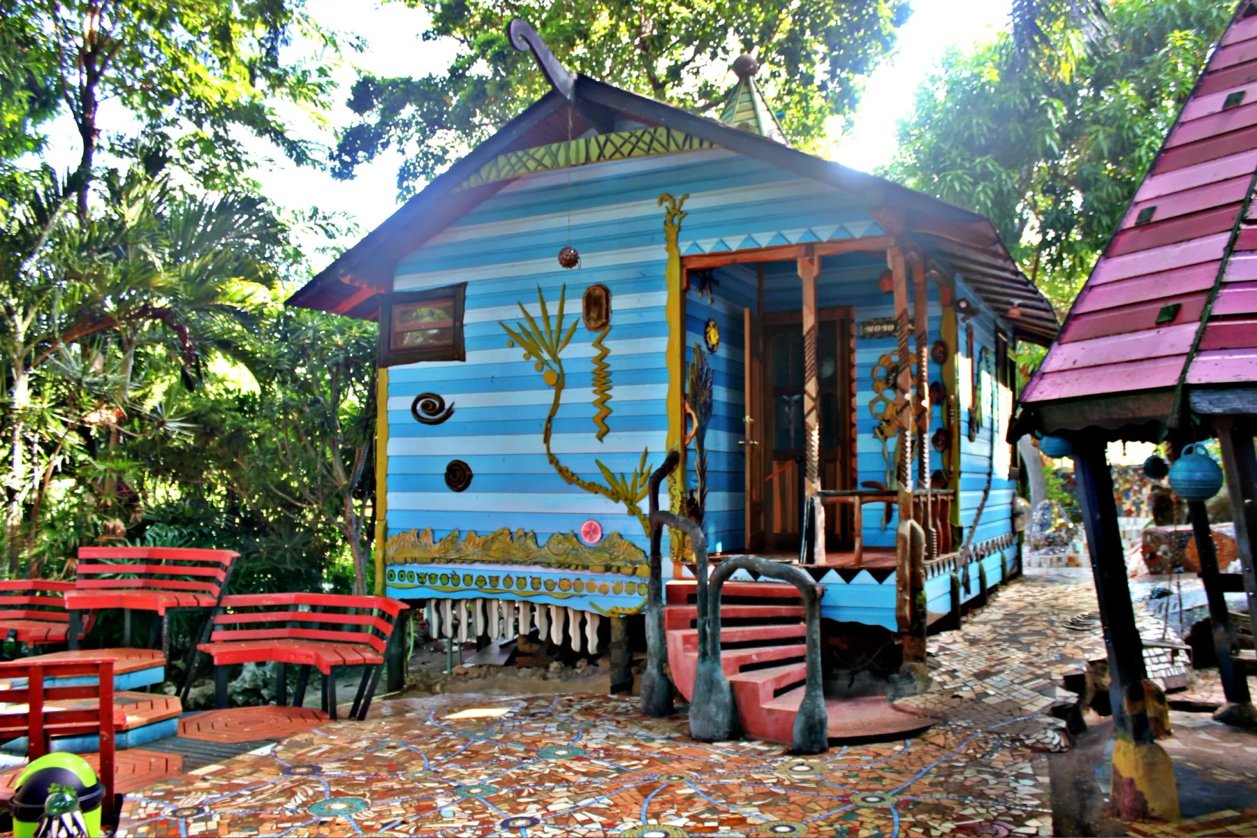 Cabaña Monolisa azul rodeada de árboles.