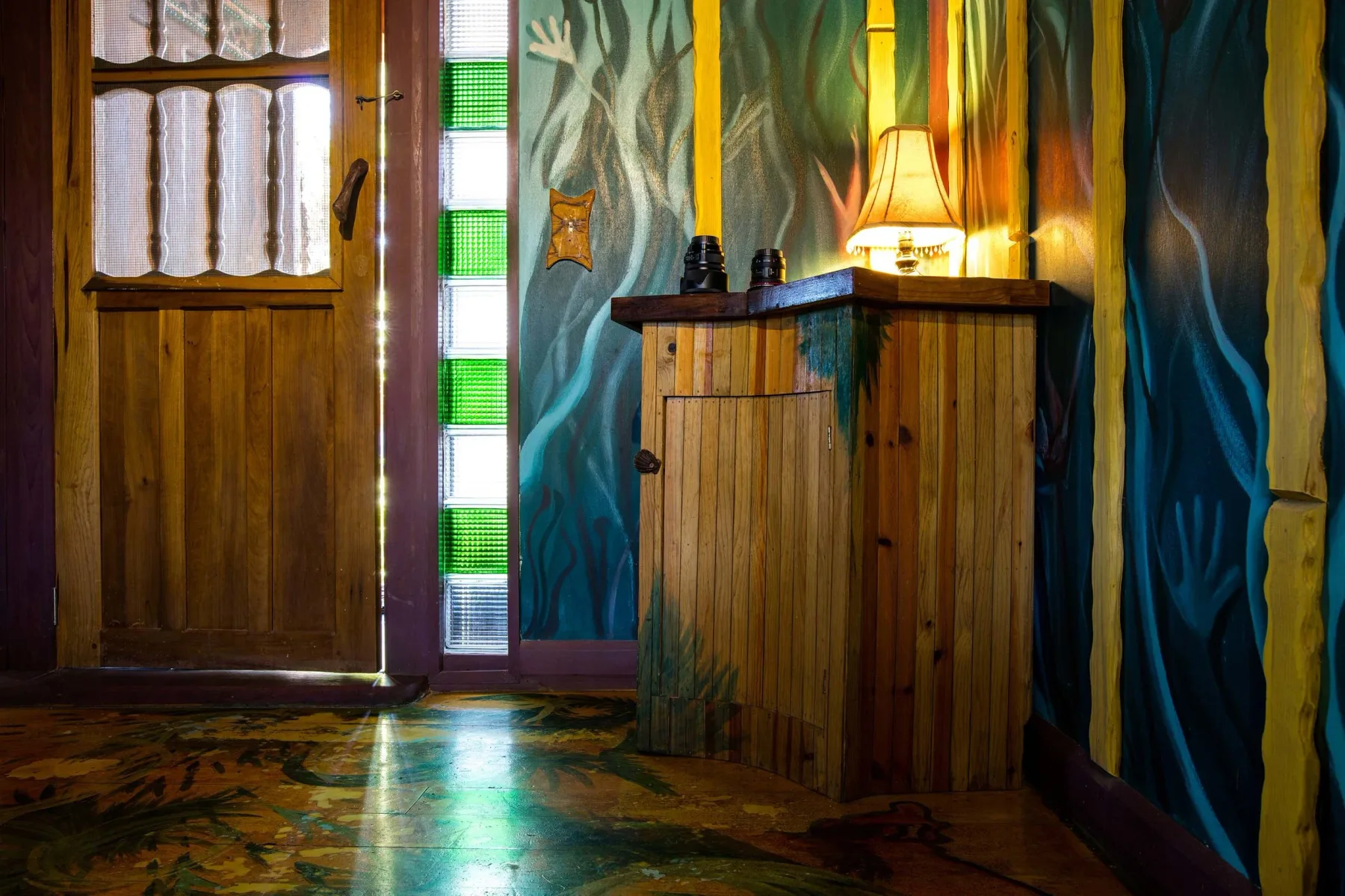 Interior de la cabaña Cuarto Qu Arto con bloques de vidrio y paredes de temática tropical.