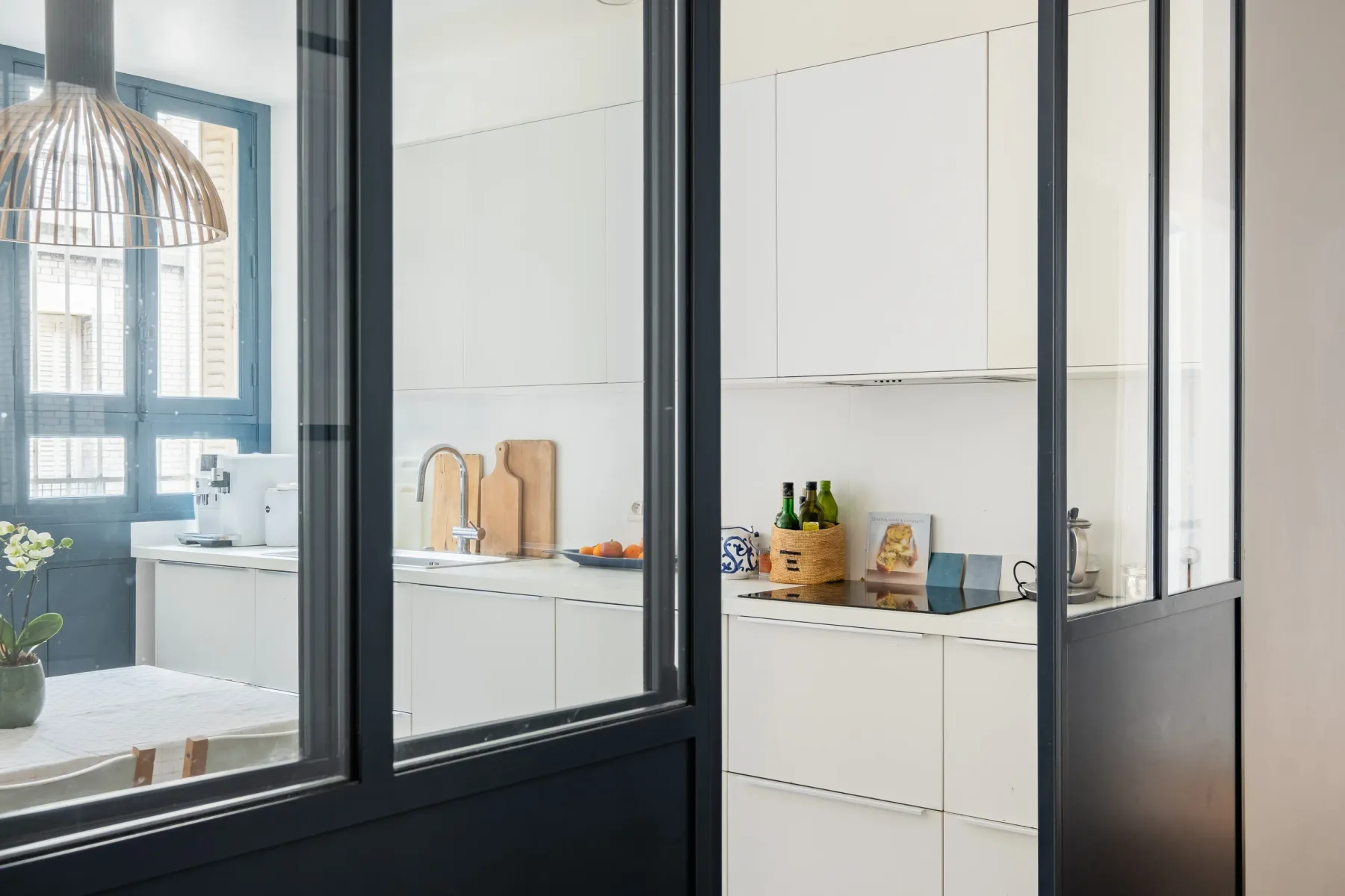 A bright kitchen with white cabinets and a window.