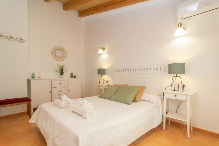 A bright bedroom with a neatly made bed and matching bedside tables.
