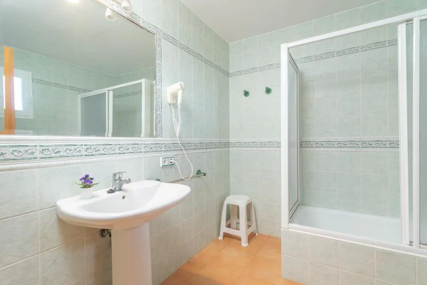 A tiled bathroom with a sink and shower.