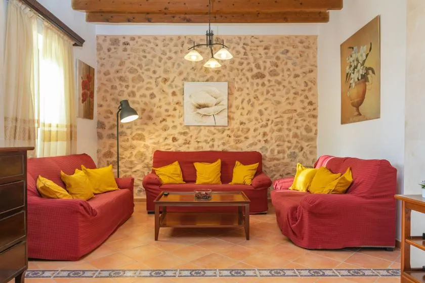 A living room with red seating arranged around a low wooden coffee table.