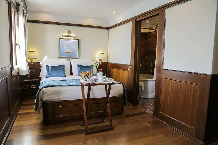 Habitación de hotel con cama, bandeja y baño contiguo con bañera.