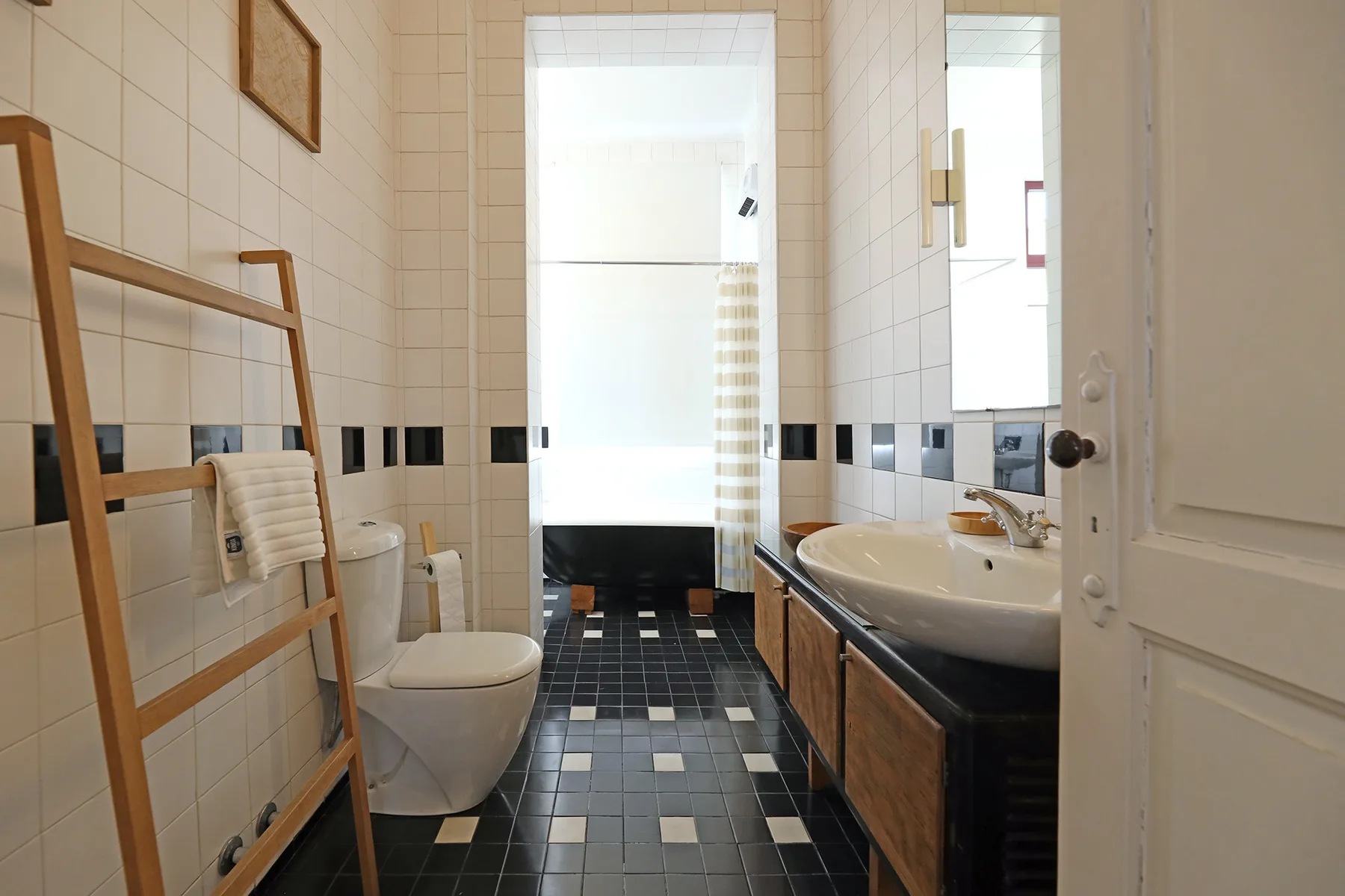 A tiled bathroom with a sink and bathtub.