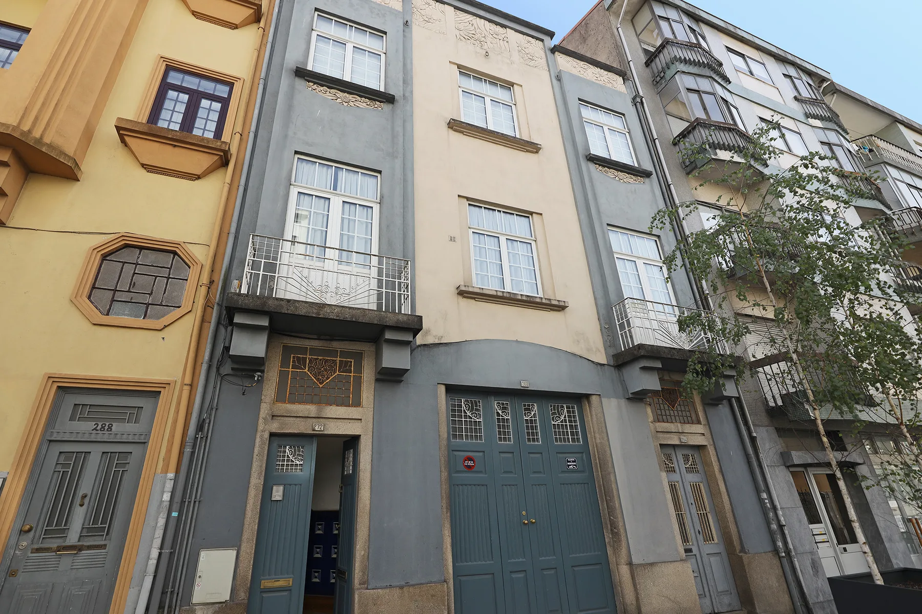Street view of adjoining multistory buildings with varied windows and balconies.