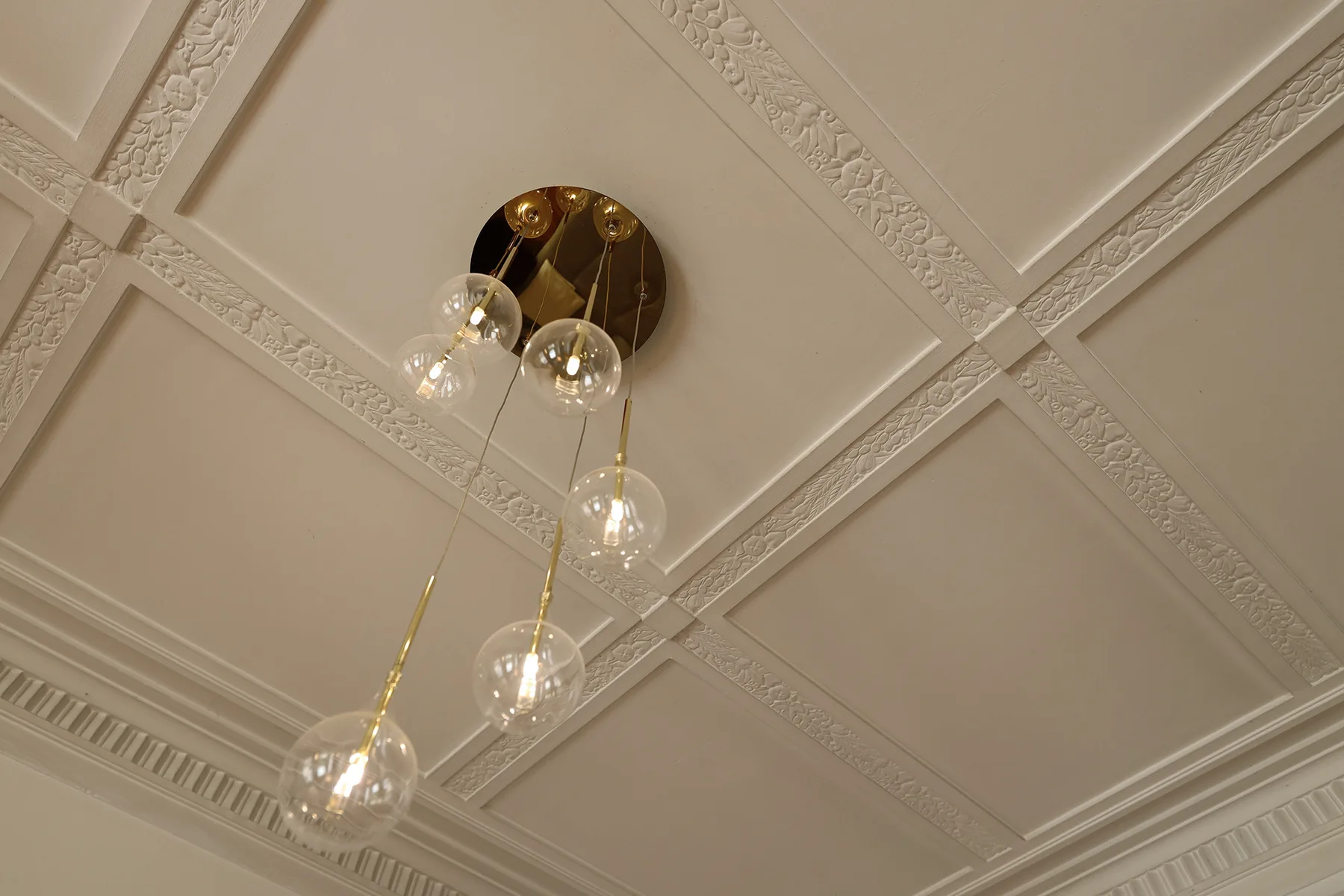 A decorative ceiling with a hanging chandelier.