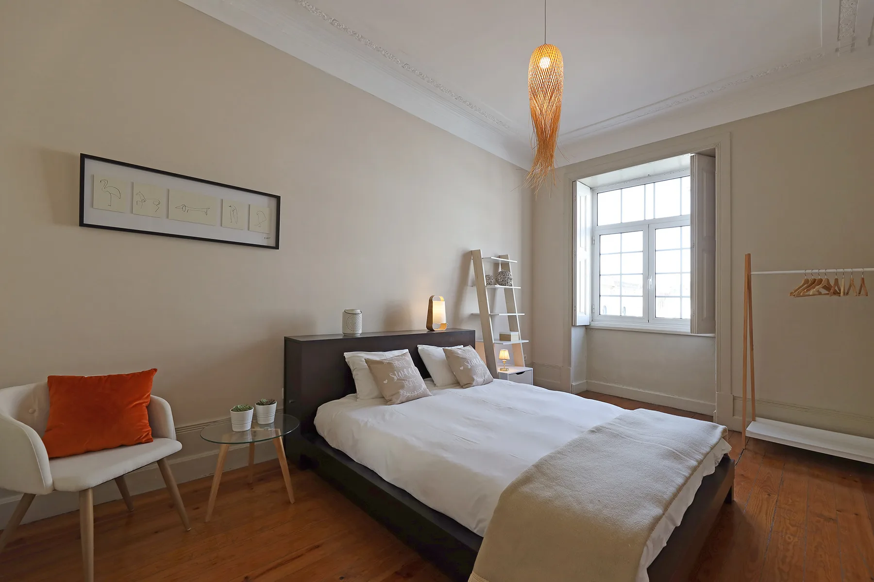 A bedroom with a bed, a chair, and a window.