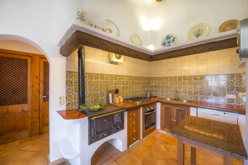 A tiled kitchen with wooden cabinets and a built-in cooking area.