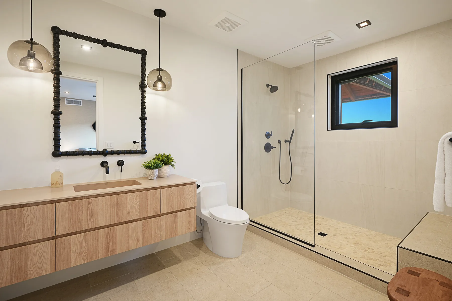 Un baño moderno con tocador, inodoro y ducha de vidrio.