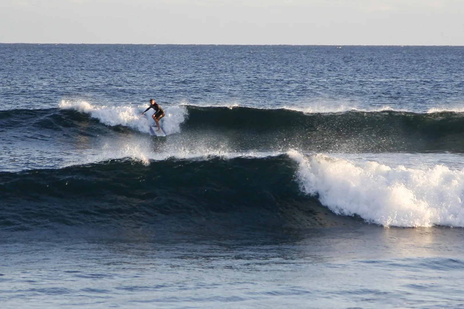 Un surfista surfea una ola rompiente.
