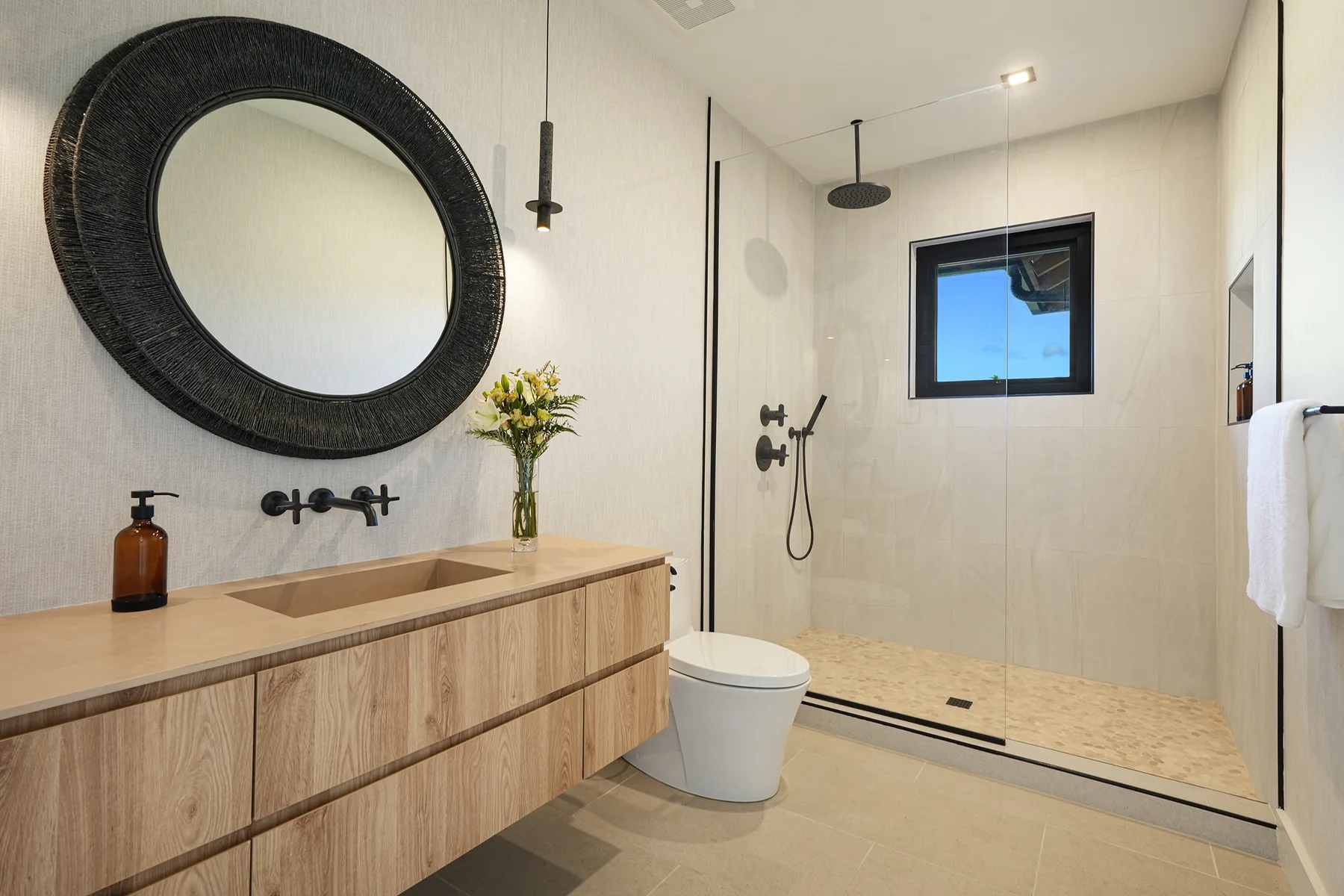 Un baño moderno con un tocador largo y una ducha a ras de suelo.