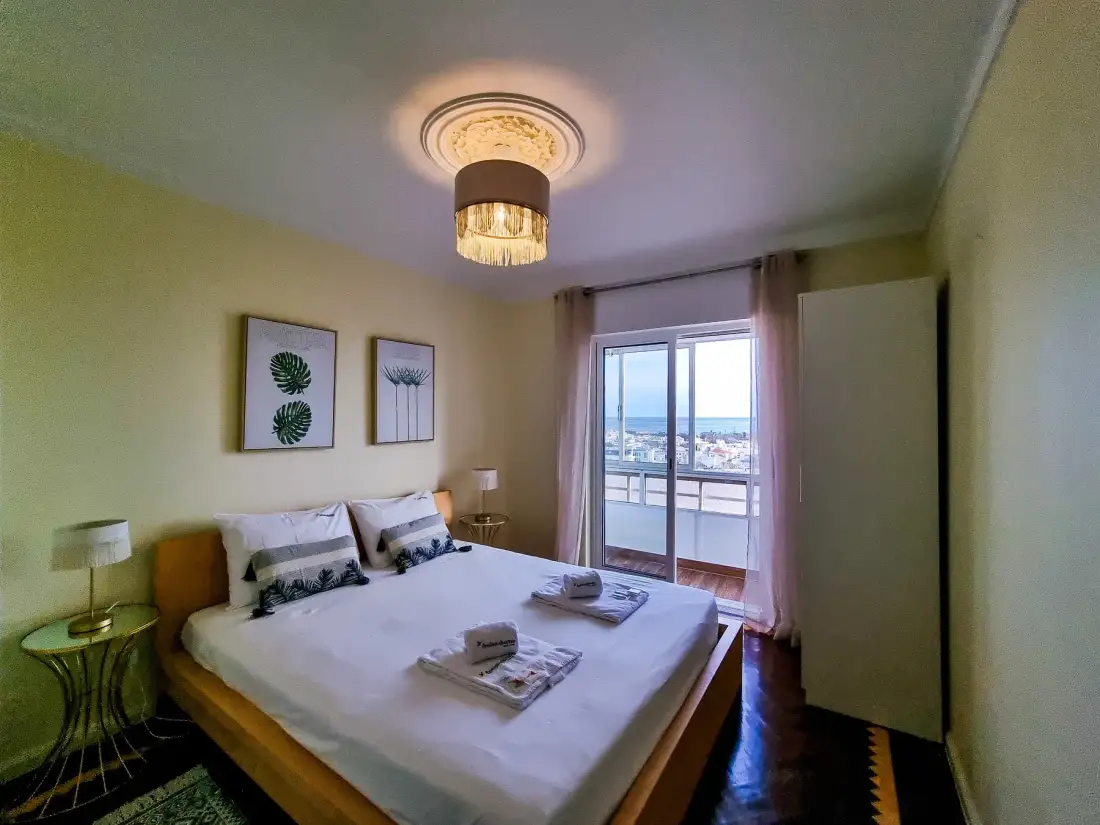 Dormitorio con una cama doble y puertas de vidrio que dan a un balcón.