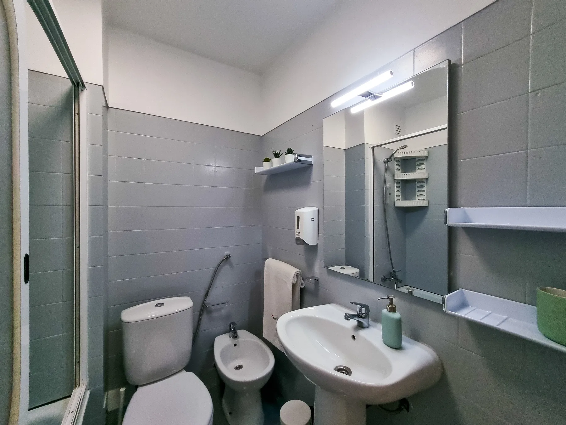 Un baño alicatado con lavabo, inodoro y bidé.
