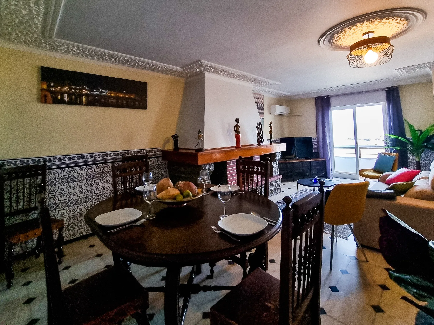 Un comedor y sala de estar con una mesa junto a una chimenea.